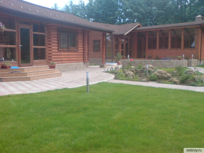 Деревянный дом и зеленый газон фото